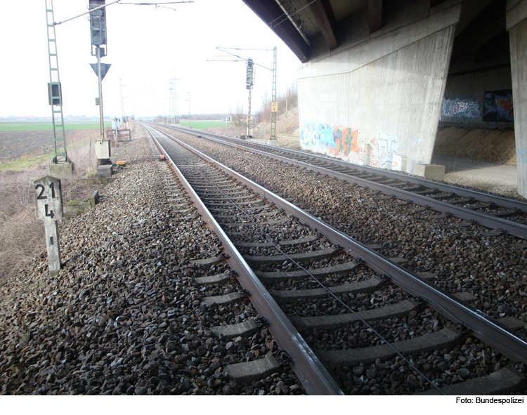 Kinder legen Schottersteine auf Schienen