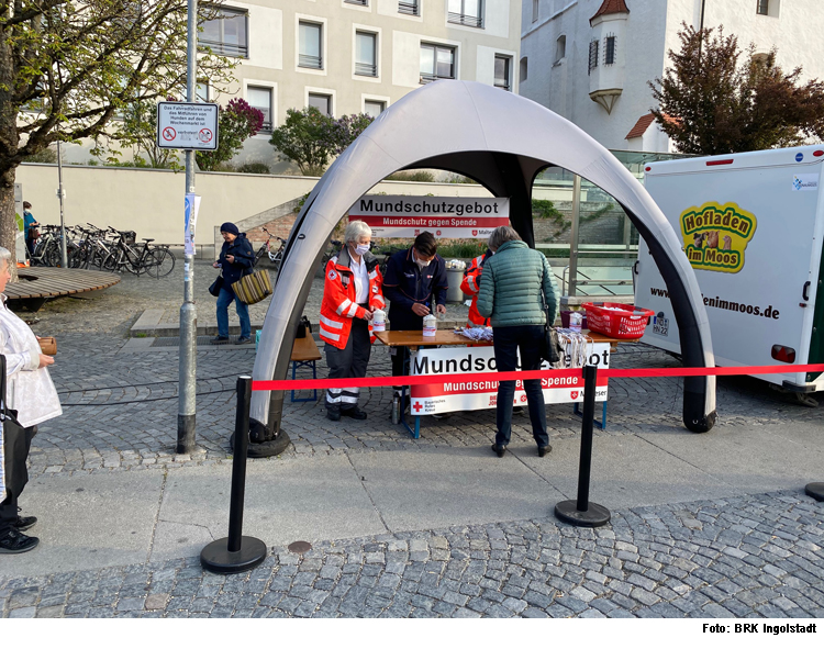 Hilfsorganisationen verteilen Masken auf Wochenmarkt