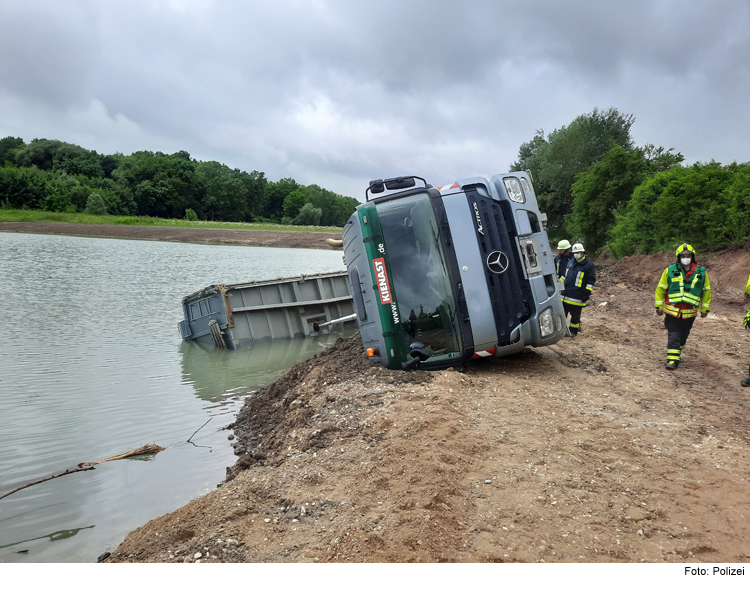 Lkw kippt in Kiesweiher