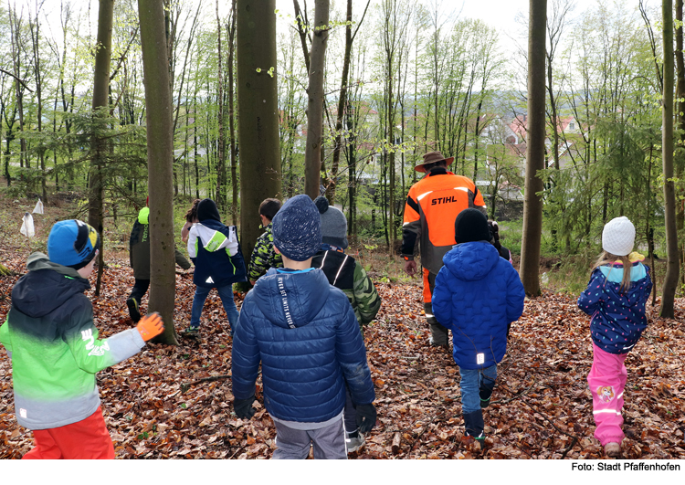 Kinder pflanzen Bäume im Schulwald 